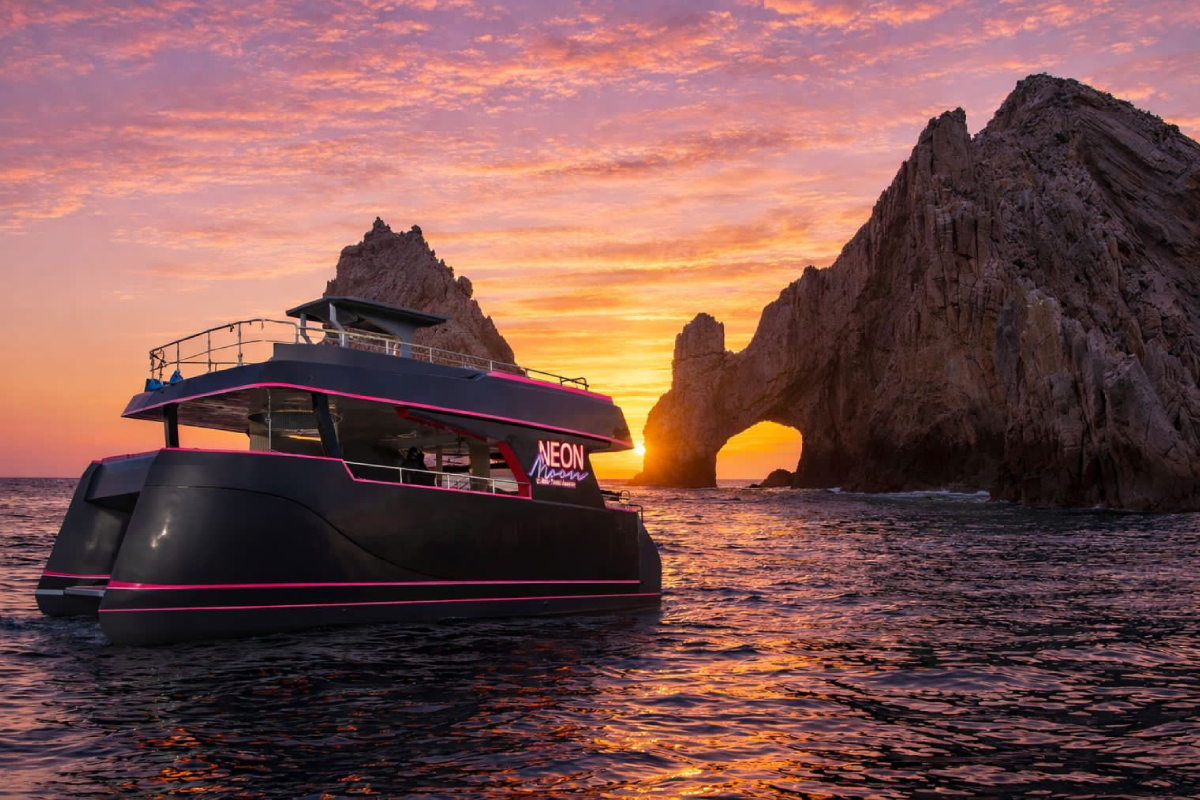 The party catamaran anchored near the Arch at sunset in Cabo San Lucas